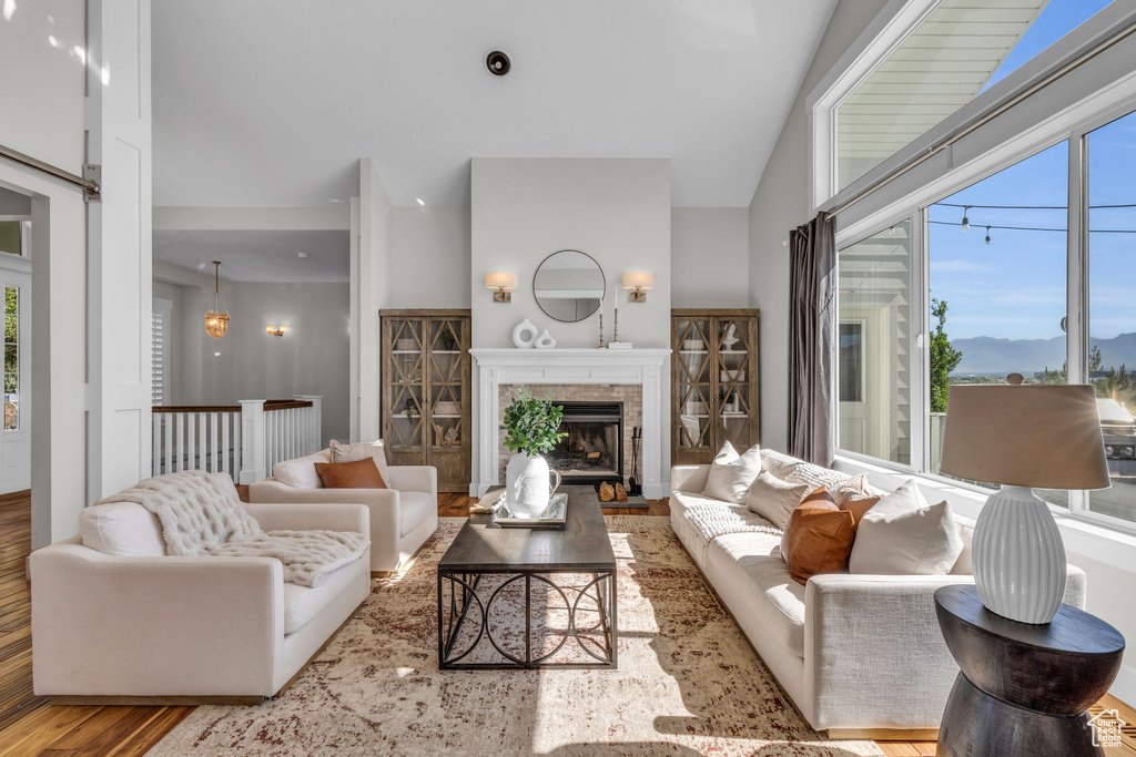 Living room with high vaulted ceiling and hardwood / wood-style floors