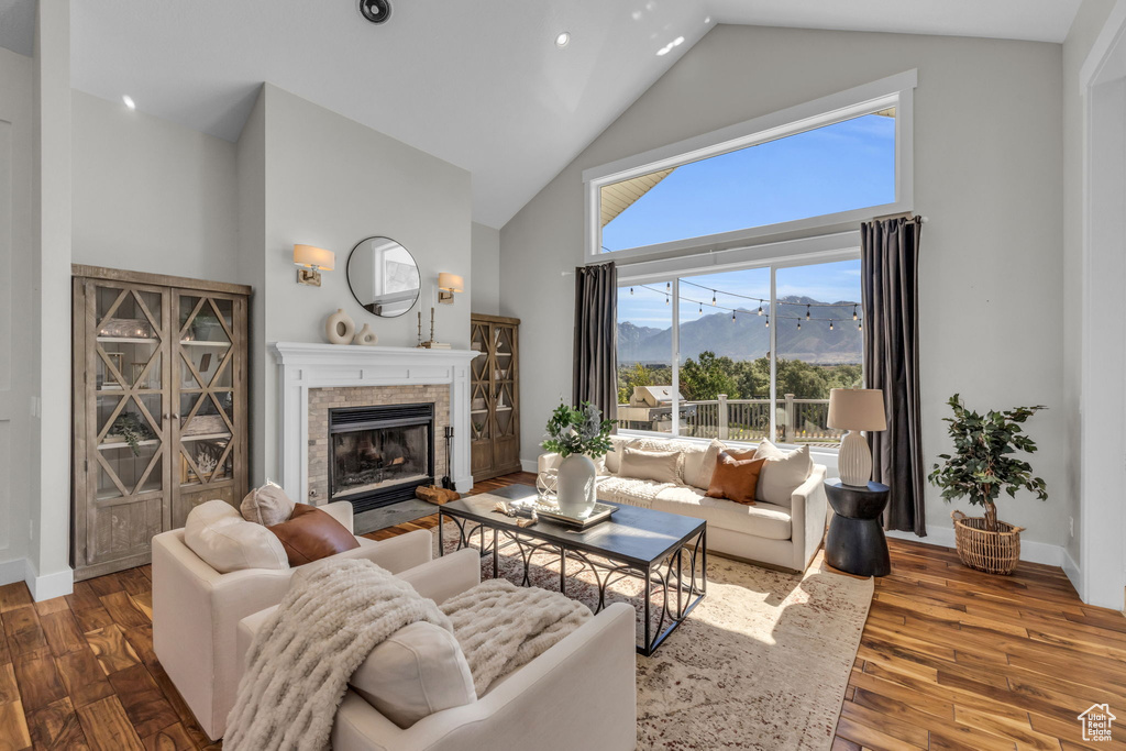 Living room with high vaulted ceiling, a mountain view, and dark hardwood / wood-style flooring