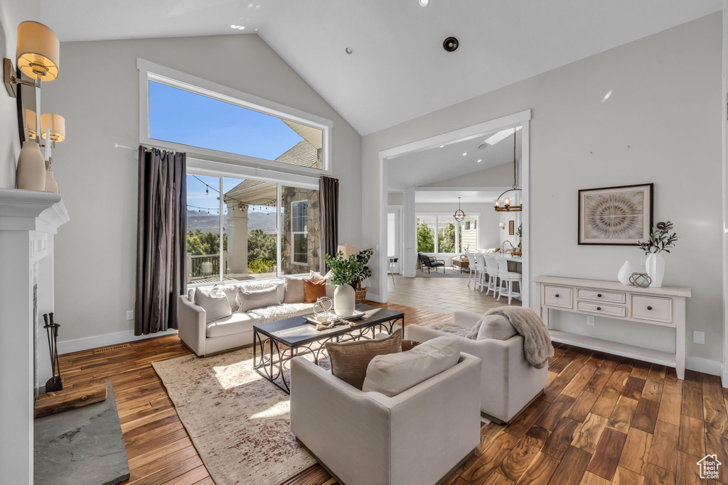 Living room with high vaulted ceiling and dark hardwood / wood-style flooring