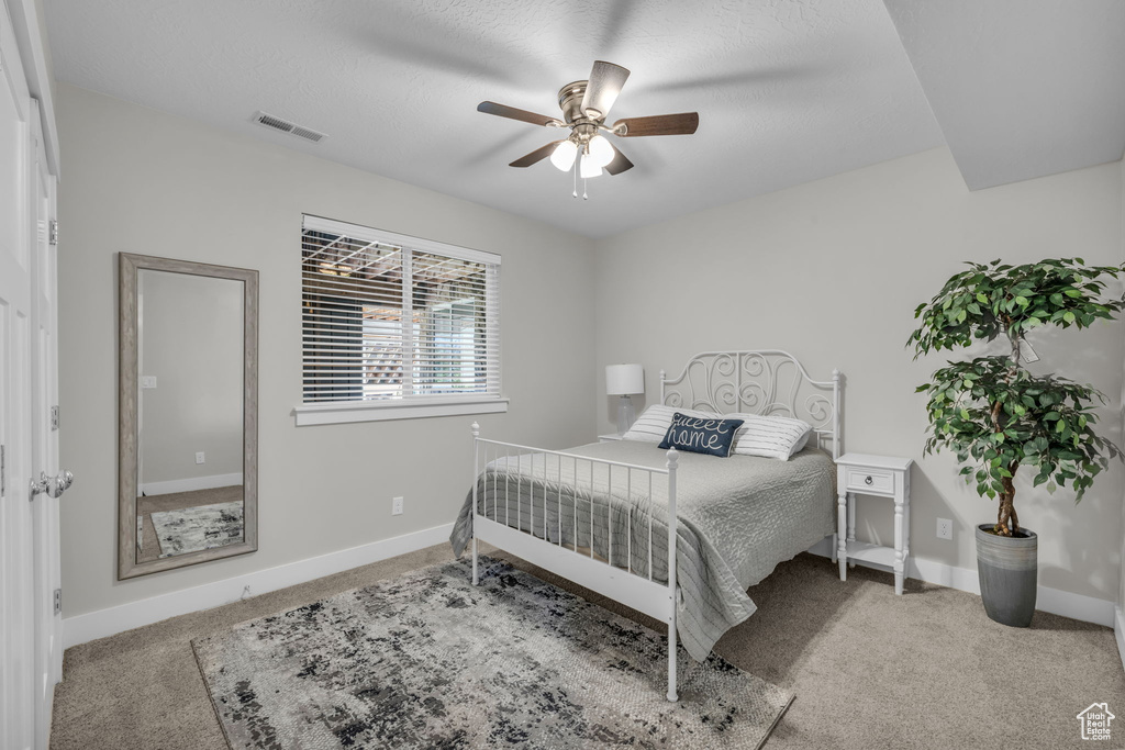 Carpeted bedroom with ceiling fan