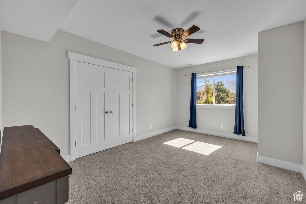 Unfurnished bedroom with carpet flooring and ceiling fan