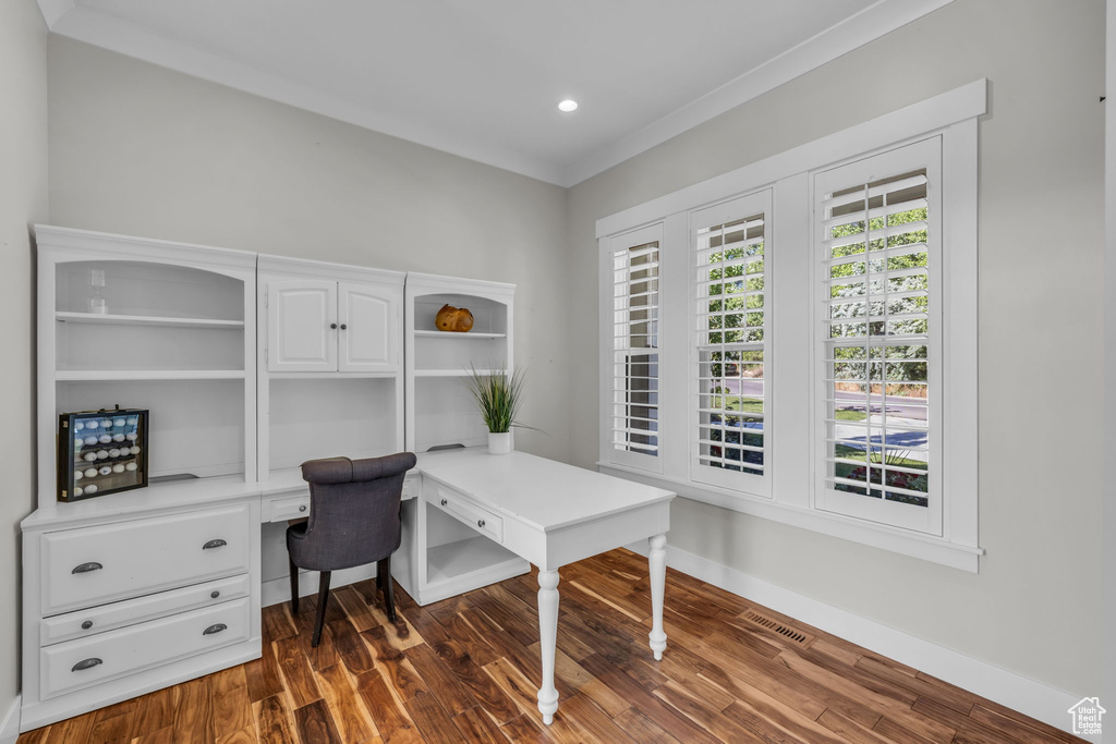 Home office with crown molding and dark wood-type flooring