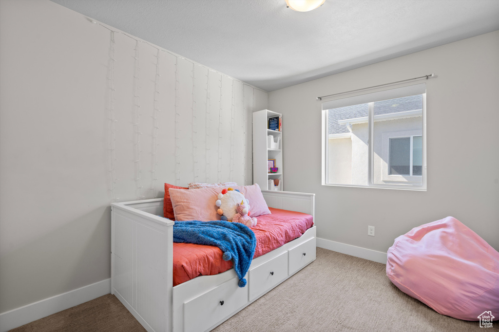 Bedroom featuring light carpet