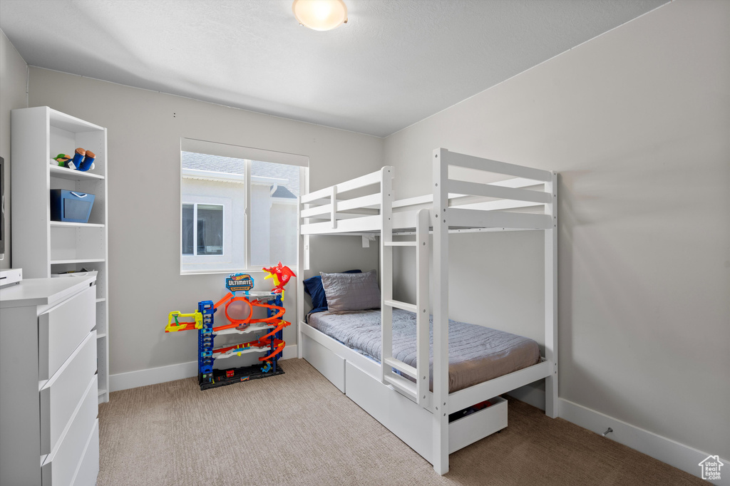 Bedroom featuring light carpet