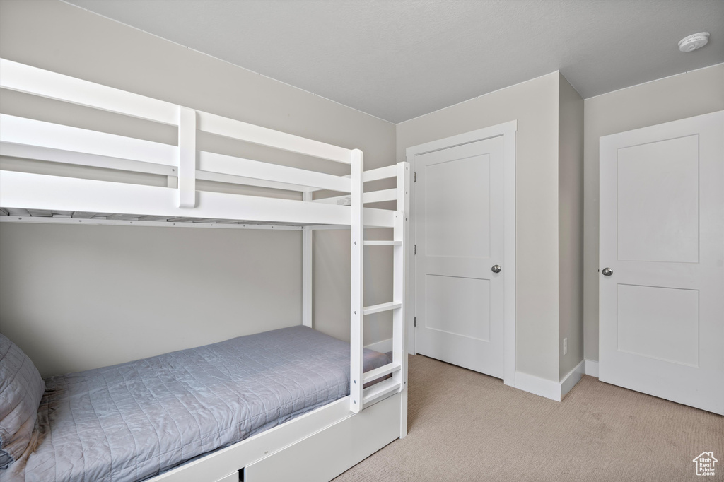 Bedroom featuring light carpet