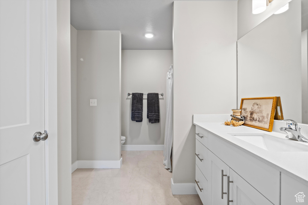 Bathroom featuring tile floors, toilet, and vanity