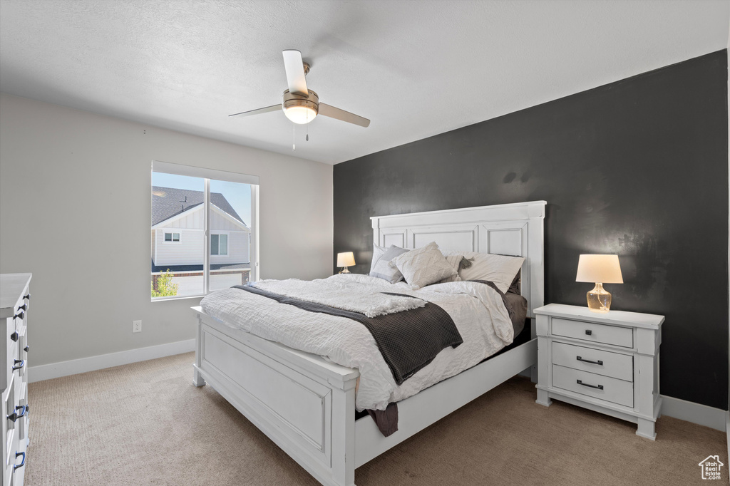 Carpeted bedroom featuring ceiling fan