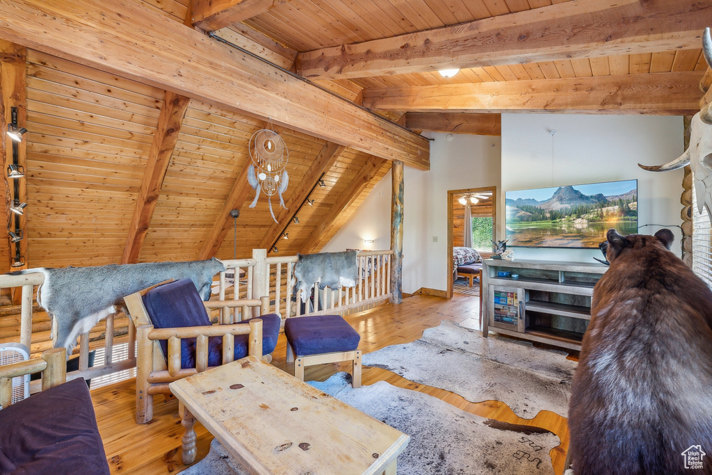 Living room featuring lofted ceiling with beams, wood ceiling, and light hardwood / wood-style flooring