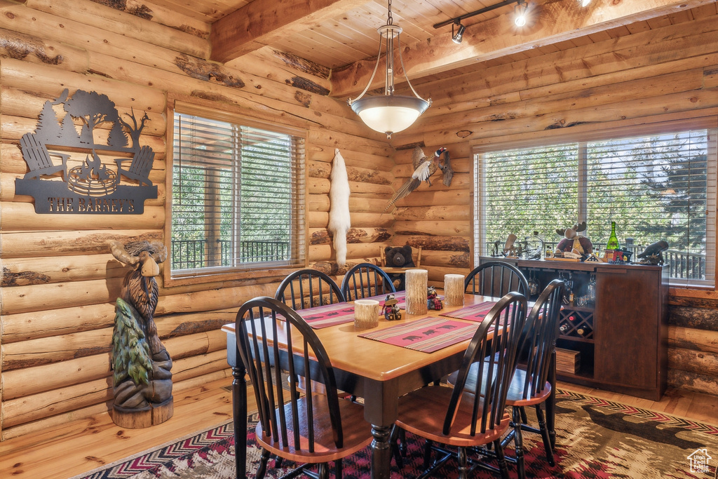 Dining area with log walls and wood ceiling