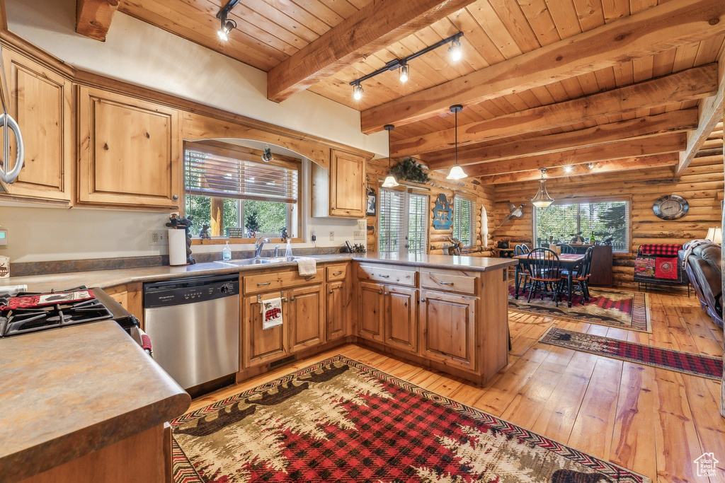 Kitchen featuring kitchen peninsula, beamed ceiling, dishwasher, rustic walls, and rail lighting