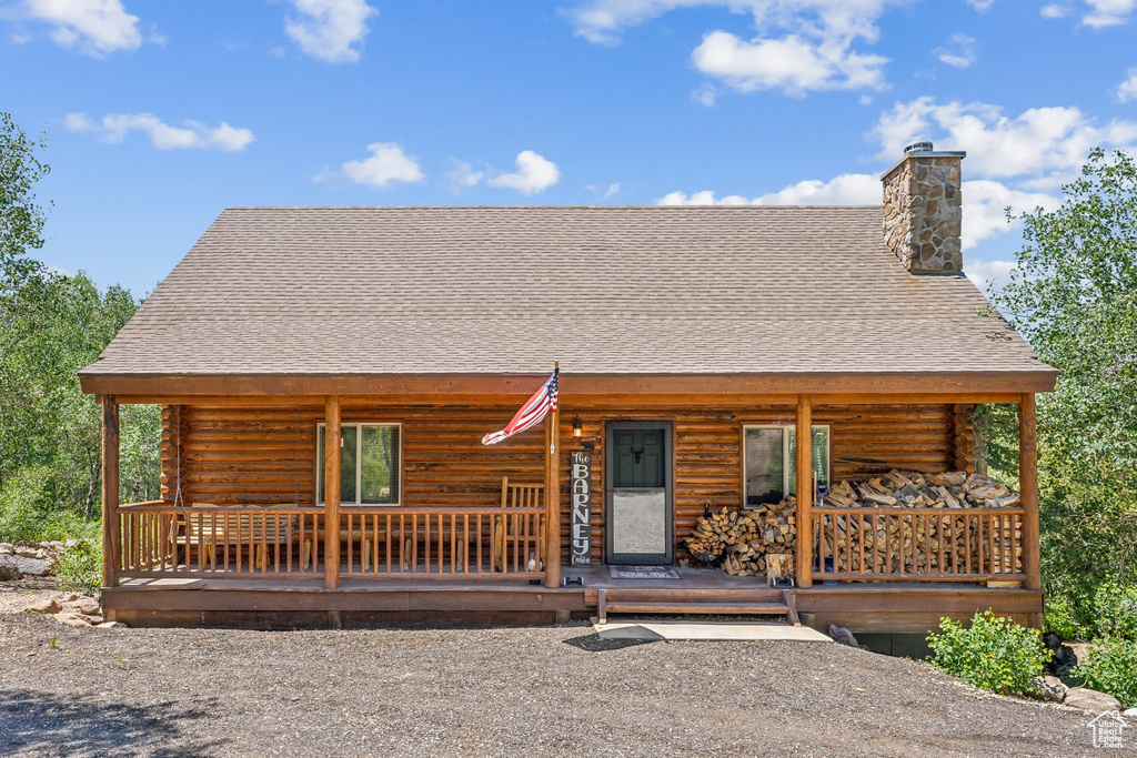 Log-style house featuring covered porch