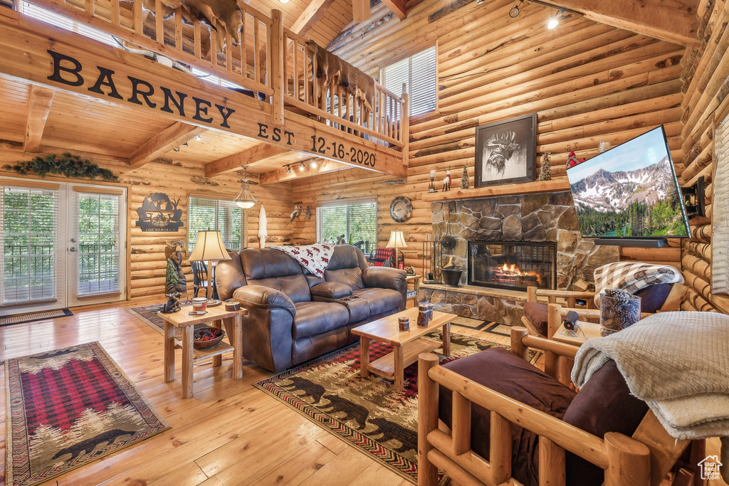 Living room featuring rustic walls, light hardwood / wood-style floors, and wood ceiling