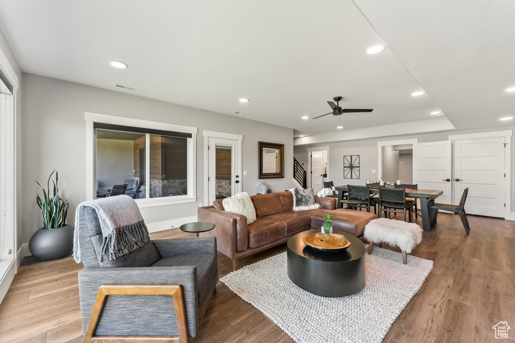 Living room featuring ceiling fan and light hardwood / wood-style flooring