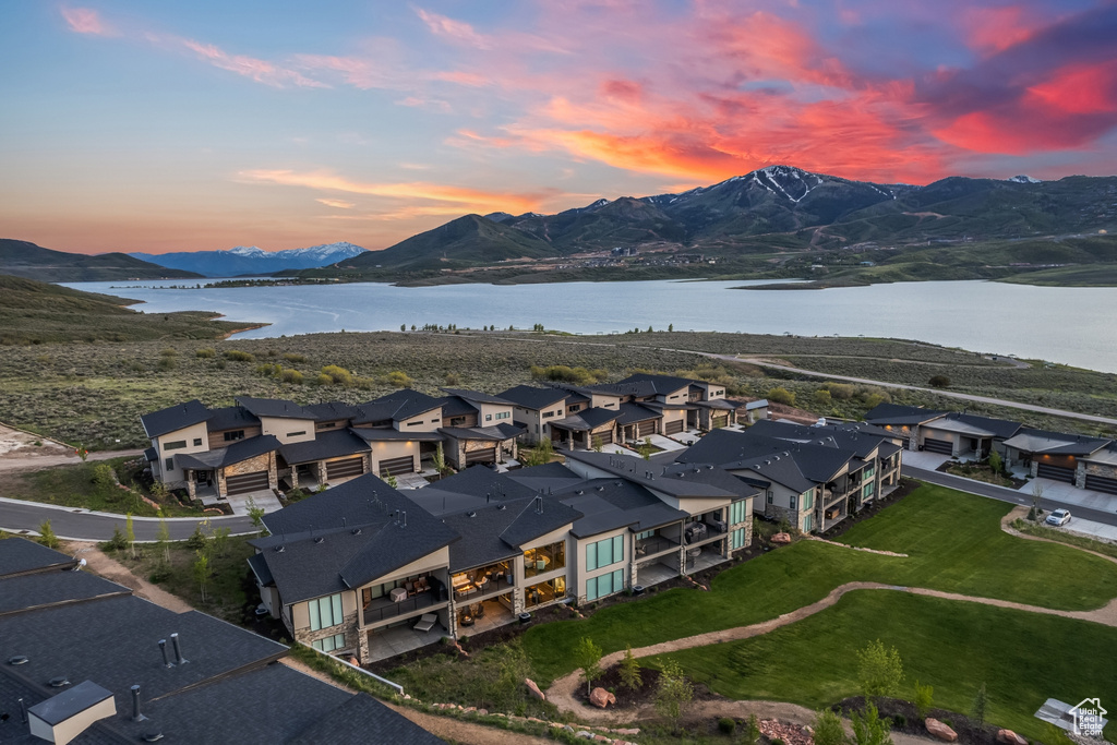 Aerial view at dusk featuring a water and mountain view