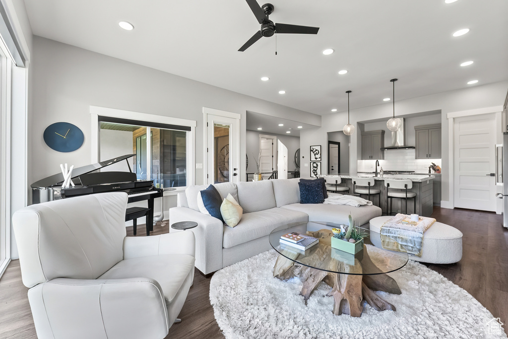 Living room with ceiling fan, a healthy amount of sunlight, sink, and wood-type flooring