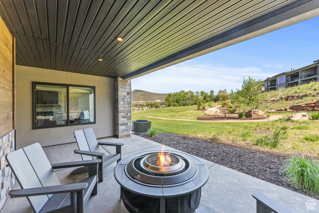 View of terrace with an outdoor fire pit and central AC unit