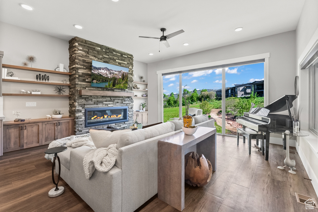 Living room featuring dark hardwood / wood-style floors, ceiling fan, and a fireplace