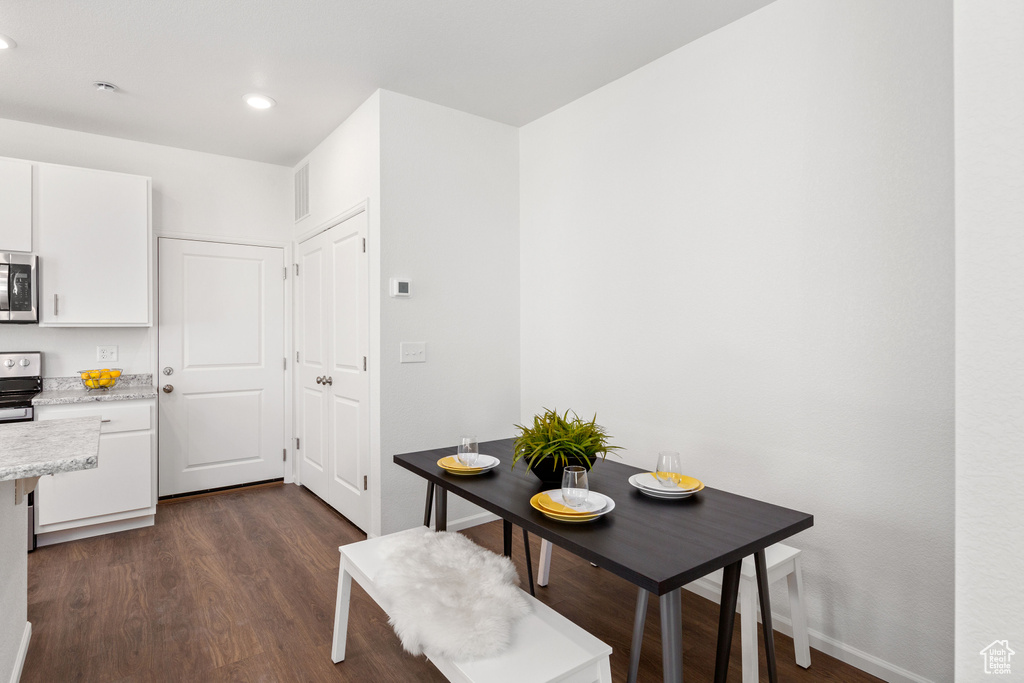 Dining area featuring dark wood-type flooring