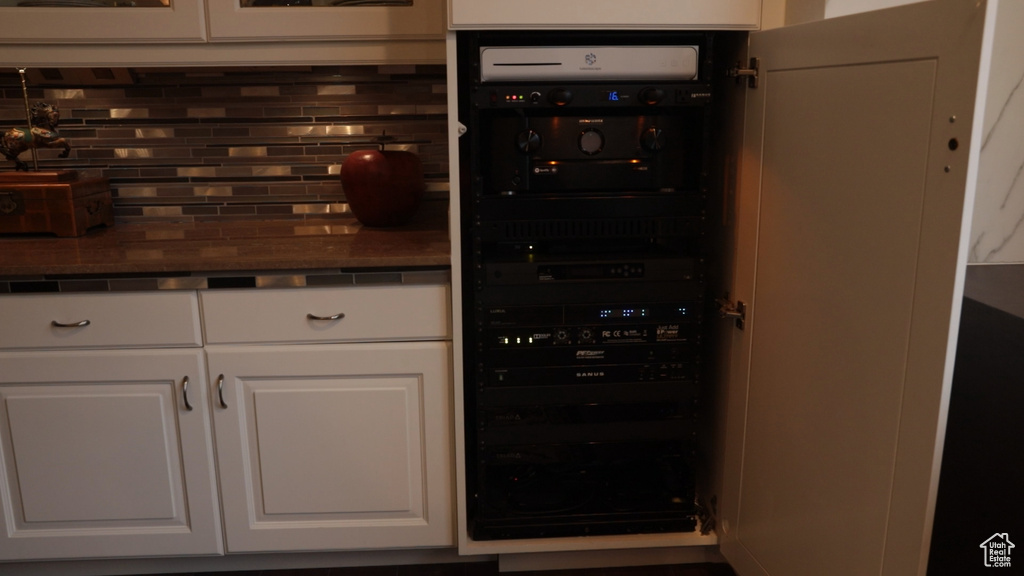 Kitchen featuring backsplash and white cabinets