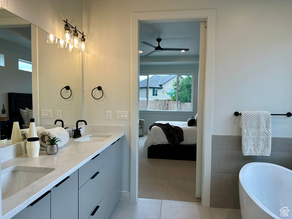 Bathroom with ceiling fan, a bath, double sink vanity, and tile patterned floors