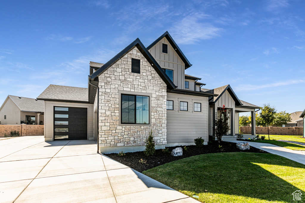 View of front of property featuring a front yard and a garage