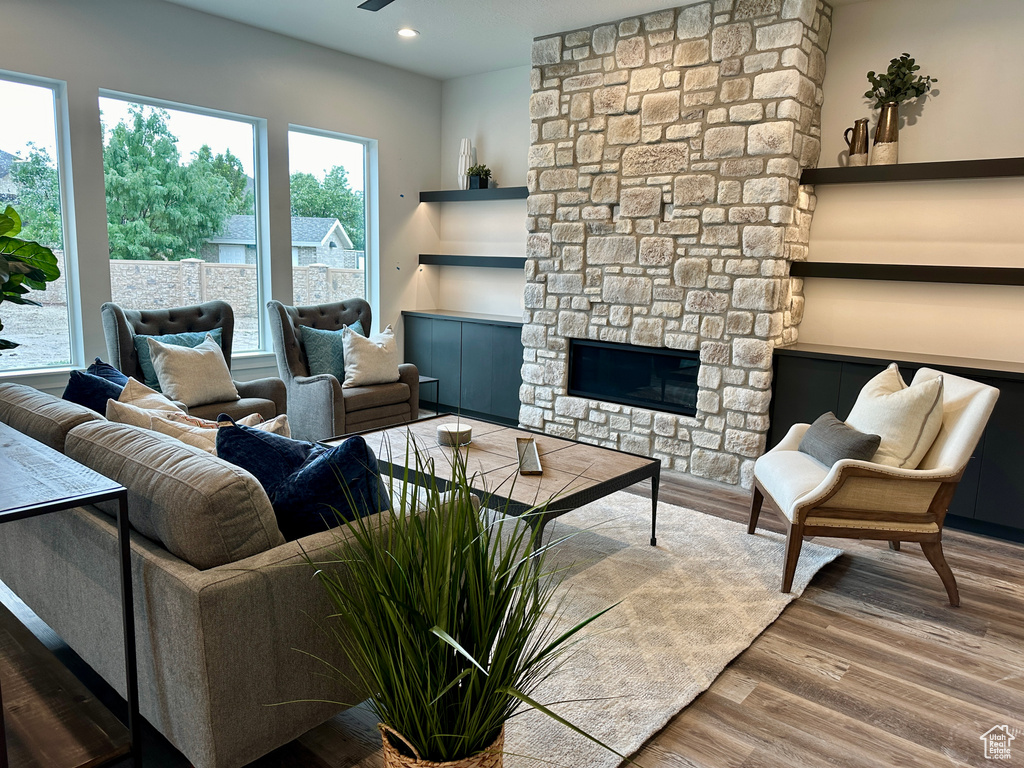 Living room with hardwood / wood-style floors and a stone fireplace