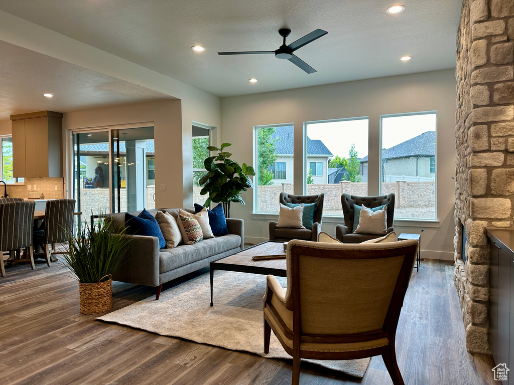 Living room with ceiling fan and dark hardwood / wood-style flooring