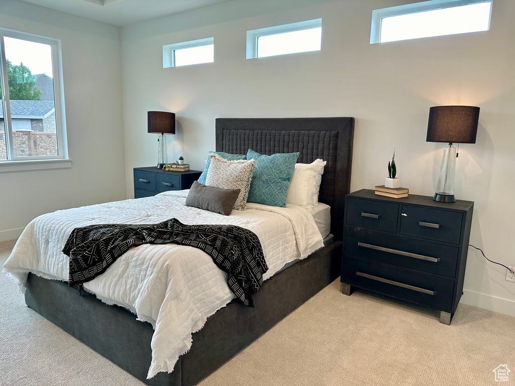 Carpeted bedroom featuring multiple windows