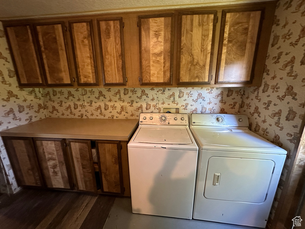 Laundry room featuring washer and clothes dryer and cabinets