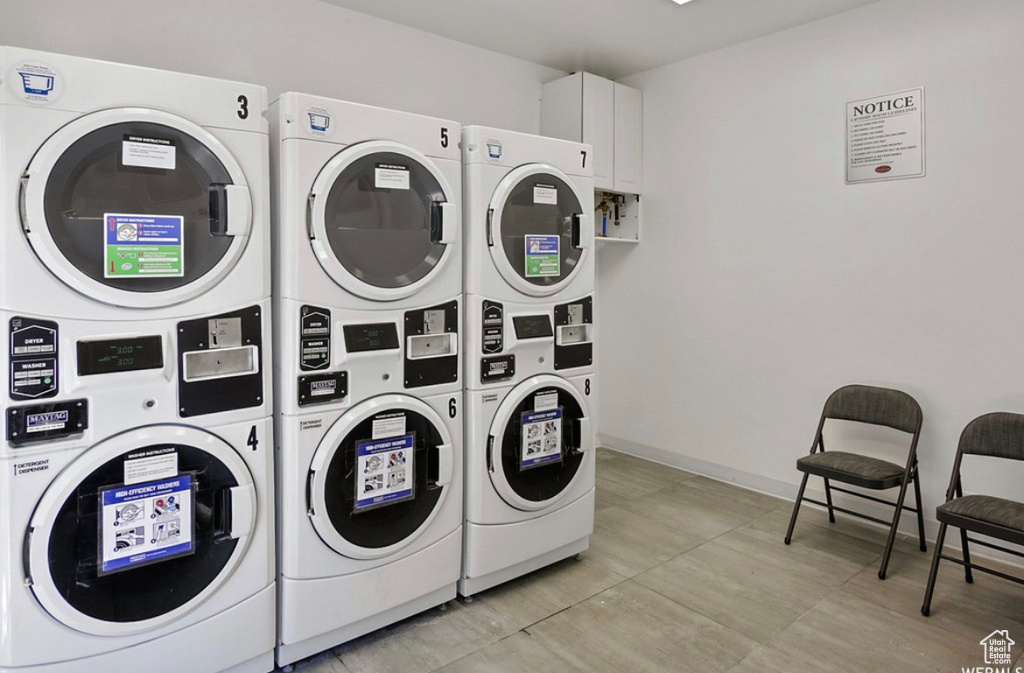 Laundry area featuring washer and clothes dryer, stacked washer and clothes dryer, and light tile flooring