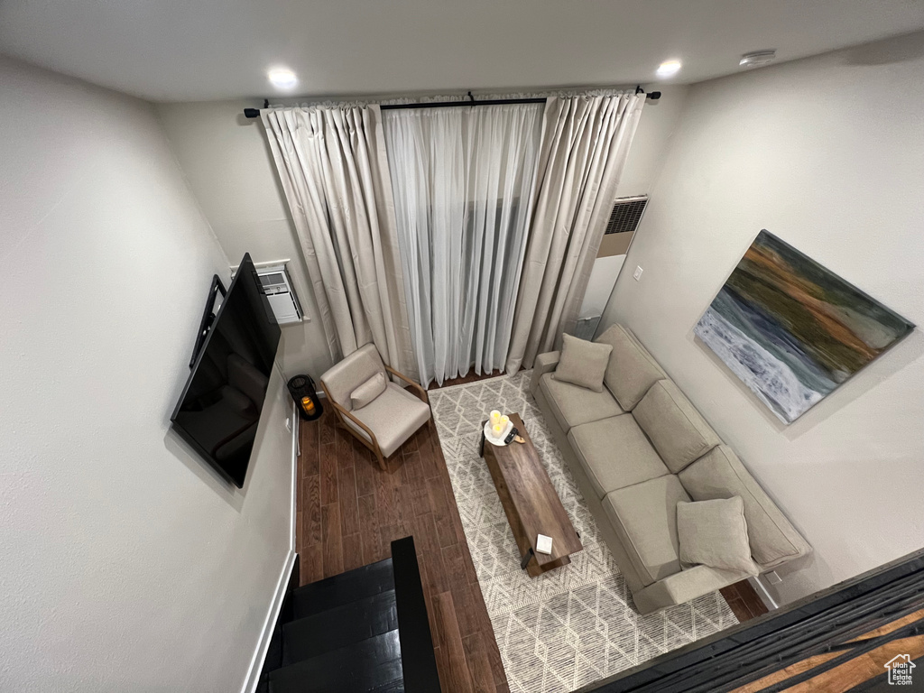 Living room featuring a towering ceiling and dark hardwood / wood-style flooring