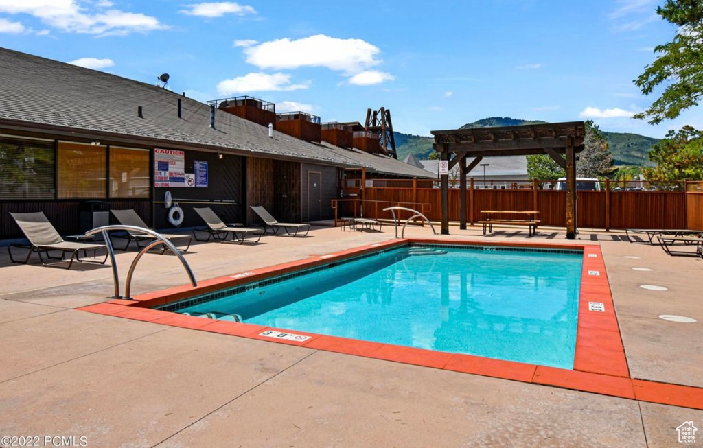 View of pool with a pergola and a patio area