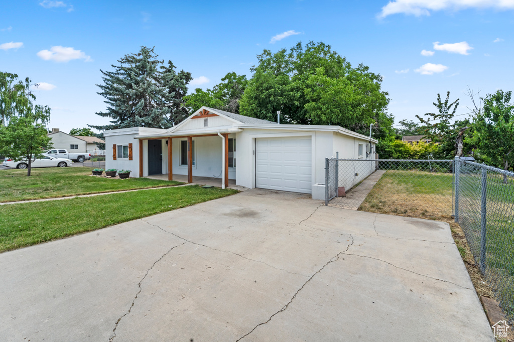 View of front of house with a garage and a front yard