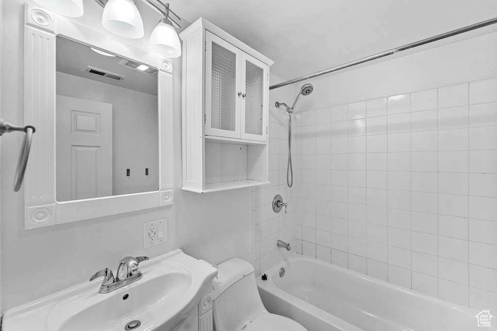 Full bathroom featuring sink, toilet, and tiled shower / bath combo