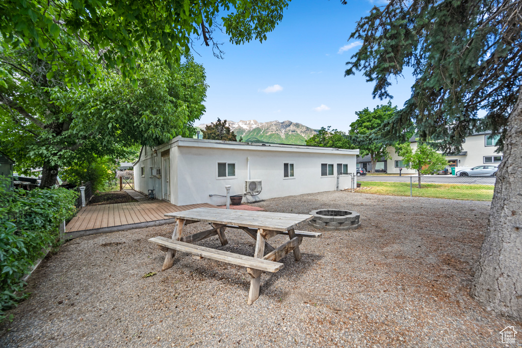 Back of property with an outdoor fire pit and a deck with mountain view