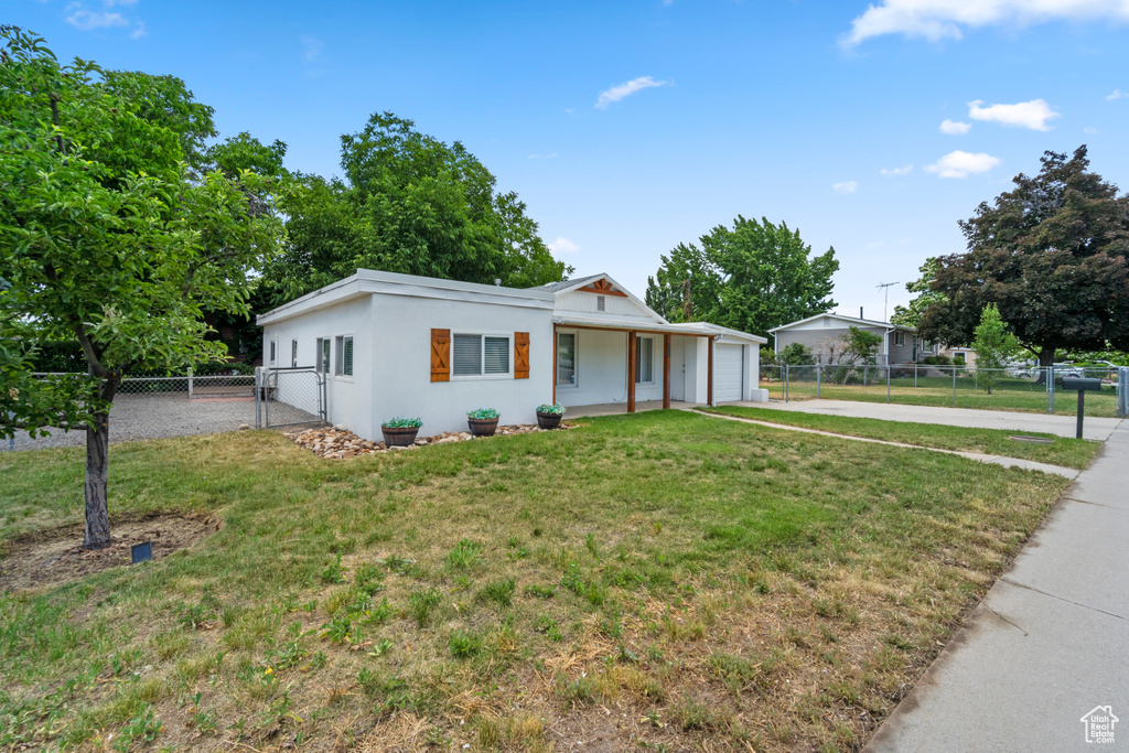 Ranch-style house with a garage and a front lawn