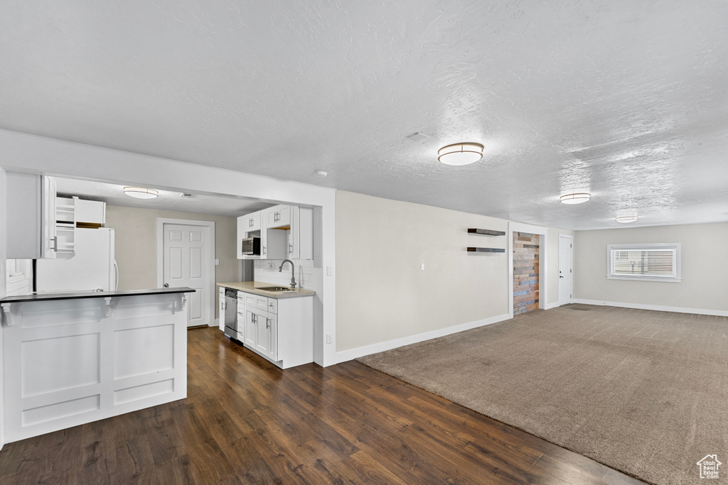 Kitchen featuring dark hardwood / wood-style flooring, white cabinets, tasteful backsplash, sink, and white fridge