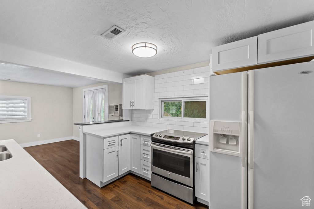 Kitchen featuring white fridge with ice dispenser, dark hardwood / wood-style flooring, backsplash, and stainless steel electric range