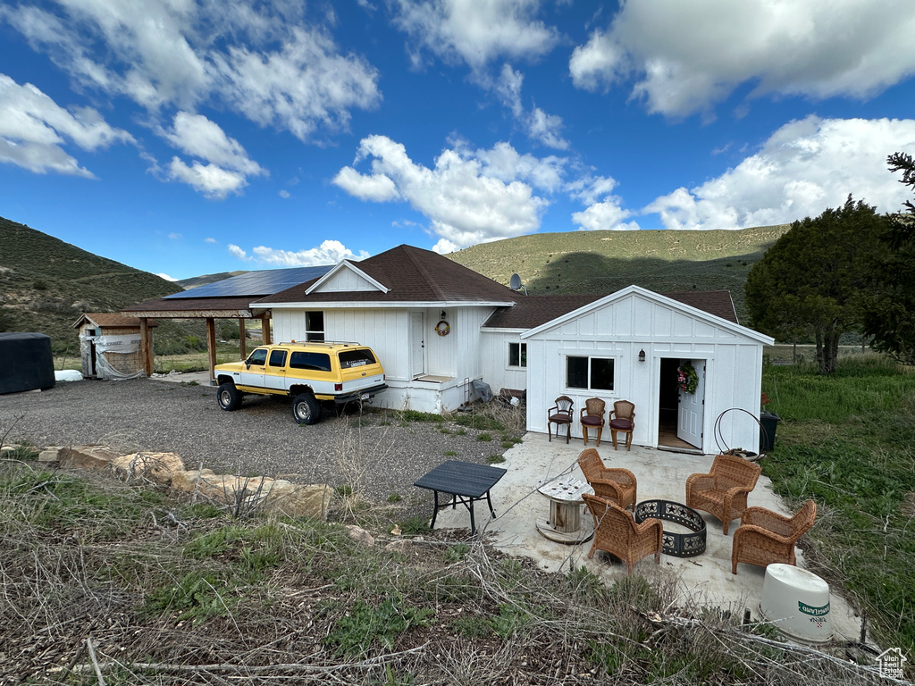 Rear view of house with an outdoor structure and a patio