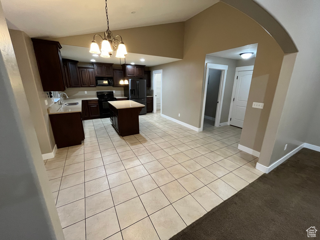 Kitchen featuring a kitchen island, light carpet, black appliances, dark brown cabinets, and decorative light fixtures