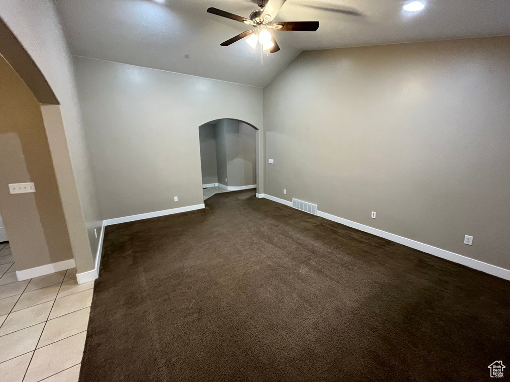 Unfurnished room with tile floors, lofted ceiling, and ceiling fan