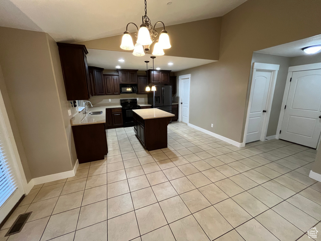 Kitchen featuring pendant lighting, black appliances, dark brown cabinetry, a center island, and a chandelier