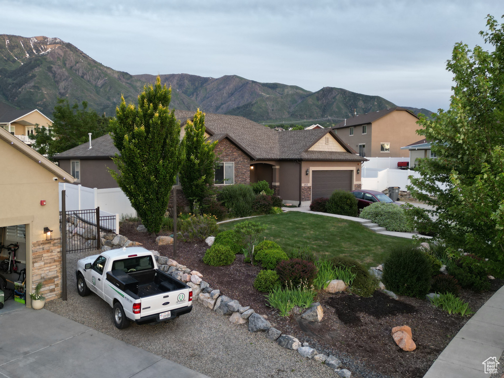 View of front of home featuring a garage, a front yard, and a mountain view