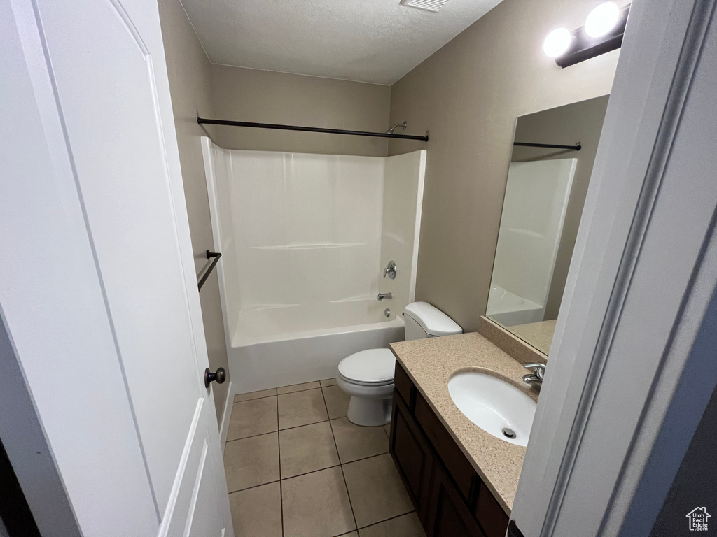 Full bathroom with a textured ceiling, tile floors, shower / washtub combination, vanity, and toilet