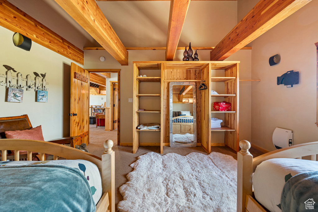 Carpeted bedroom with beam ceiling