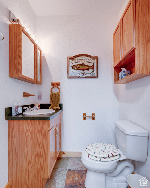 Bathroom with vanity, toilet, and tile floors