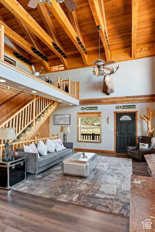 Living room with dark wood-type flooring, ceiling fan, and wood ceiling