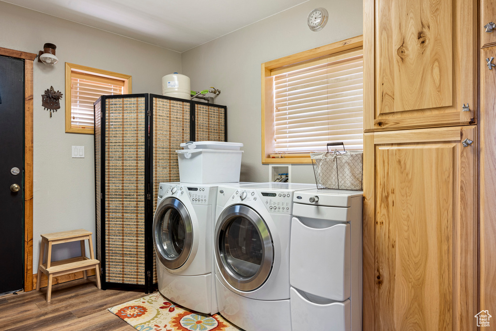 Clothes washing area featuring washer and dryer, wood-type flooring, and hookup for a washing machine