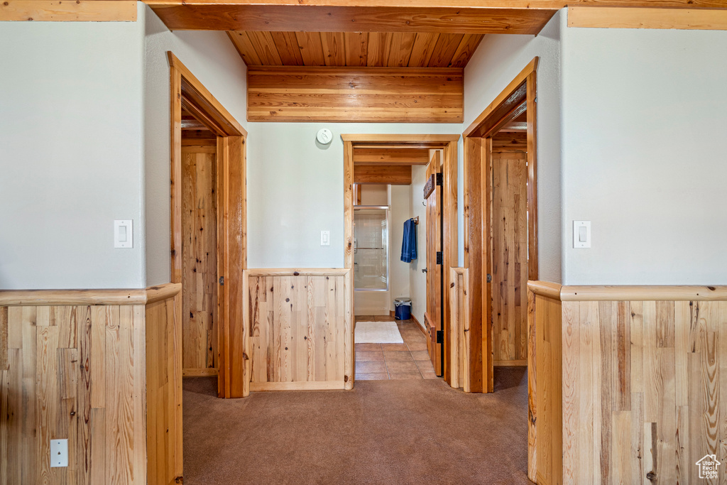 Hallway featuring beamed ceiling, wooden ceiling, and carpet floors