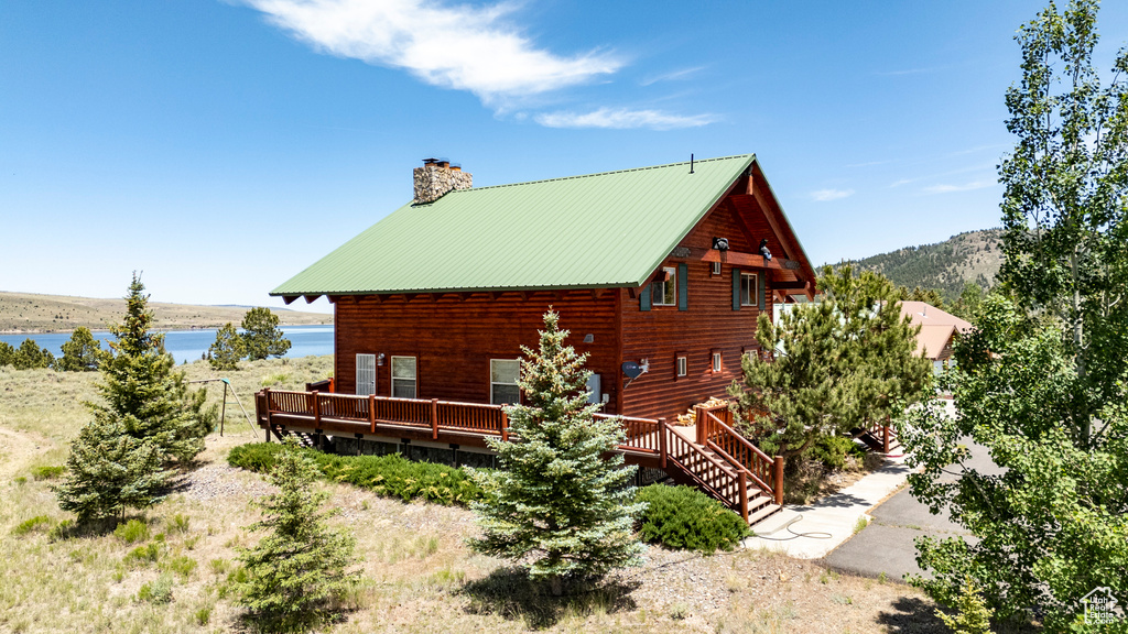 View of property exterior with a deck with water view